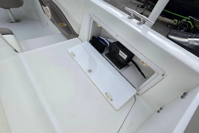 Slide: The Image of Storage compartment on a 2000 Cobalt 246 boat, featuring a white interior and equipment. - 22