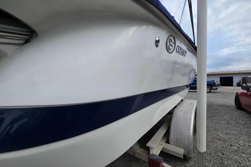 Slide: The Image of 2000 Cobalt 246 boat on trailer, side view with logo, parked outdoors. - 5