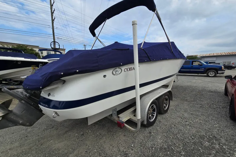 Slide: The Image of Covered 2000 Cobalt 246 boat on trailer, parked outdoors under cloudy sky. - 4