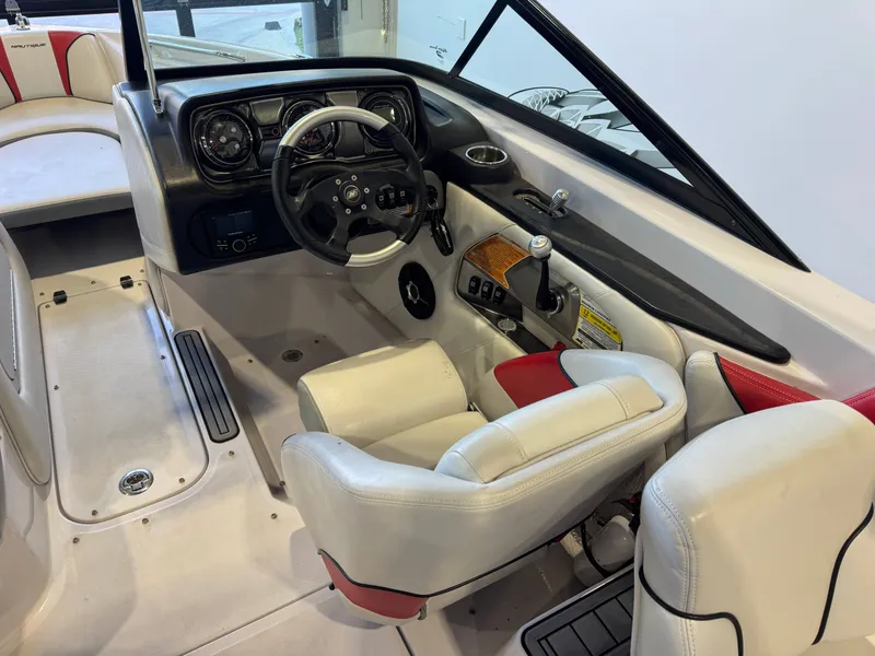 Slide: The Image of Interior of a 2011 Nautique Super Air Nautique 210 with white and red seats and black dashboard. - 23