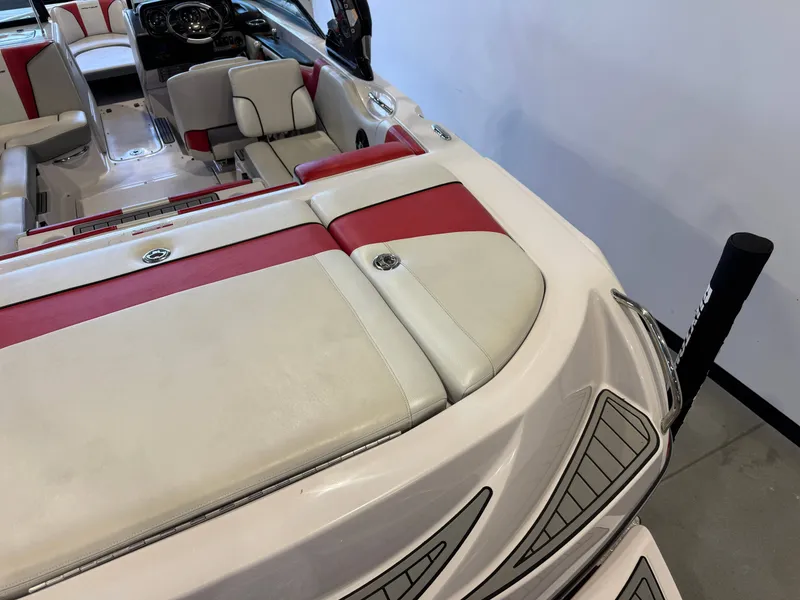 Slide: The Image of The image shows the interior of a 2011 Nautique Super Air Nautique 210 with red and white seating. - 10