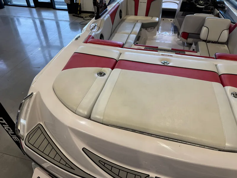 Slide: The Image of The image shows the interior of a 2011 Nautique Super Air Nautique 210 with red and white seating. - 11