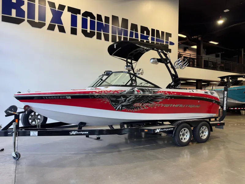 Slide: The Image of 2011 Nautique Super Air Nautique 210 on a trailer in a showroom. - 3
