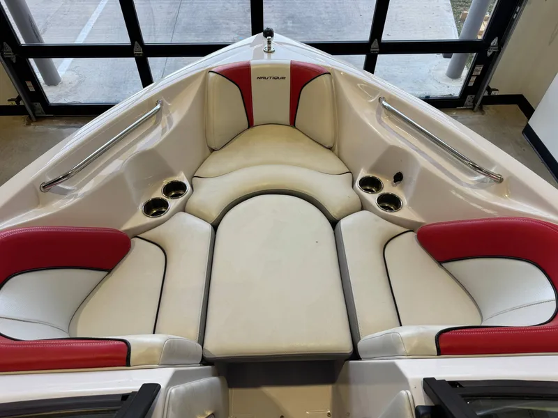 Slide: The Image of The image shows the bow area of a 2011 Nautique Super Air Nautique 210 with white and red seating. - 16
