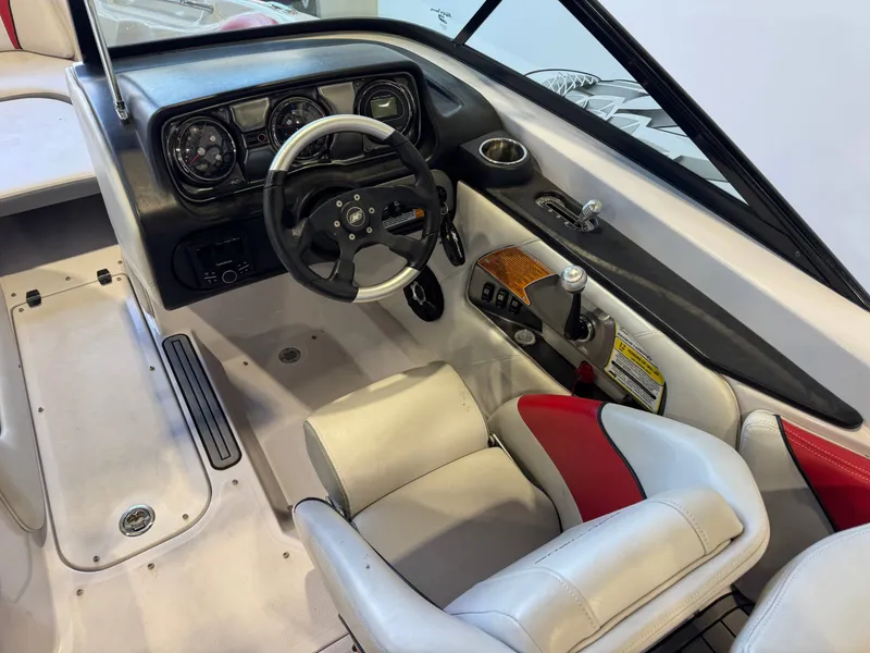 Slide: The Image of The image shows the cockpit of a 2011 Nautique Super Air Nautique 210 with a black steering wheel and white seats. - 24
