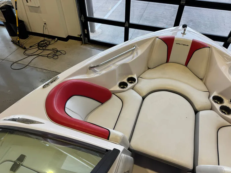 Slide: The Image of The image shows the bow of a 2011 Super Air Nautique 210 with white and red upholstery. - 18