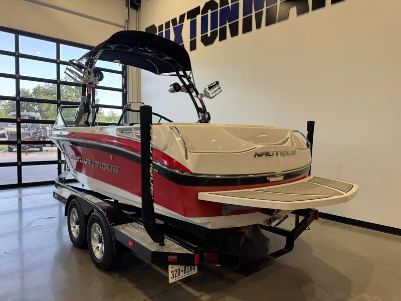 Slide: The Image of A 2011 Nautique Super Air Nautique 210 on a trailer inside a showroom. - 5