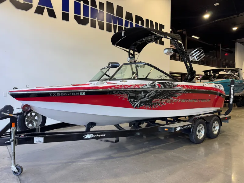 Slide: The Image of A red and white sport boat on a trailer in a showroom. - 2
