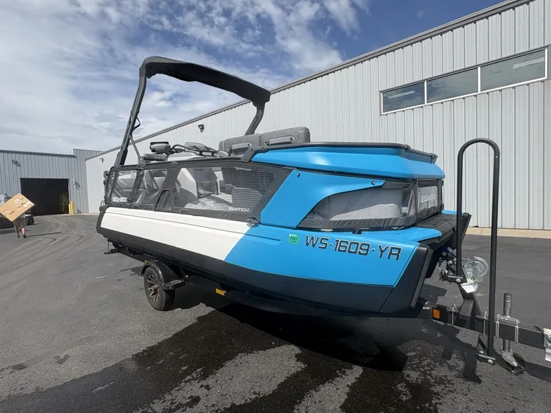 Slide: The Image of A blue and white 2023 Sea-Doo Switch Cruise 21 on a trailer in front of a building. - 6