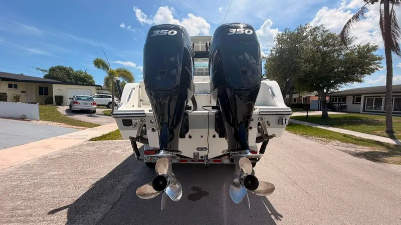 Slide: The Image of Two powerful outboard engines on a Mako 284 Center Console boat, parked on a street. - 4