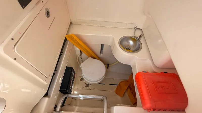 Slide: The Image of Interior of a 2015 Mako 284 Center Console boat with a sink and storage area. - 25