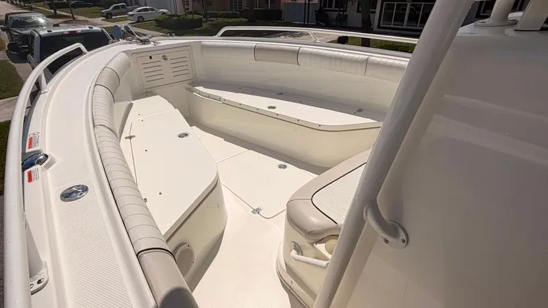 Slide: The Image of 2015 Mako 284 Center Console: Spacious white deck with cushioned seating and storage areas. - 21