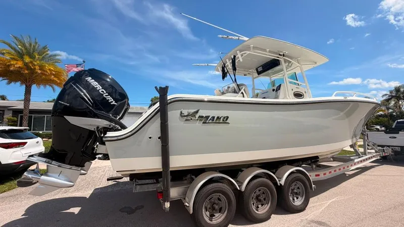 Slide: The Image of A 2015 Mako 284 Center Console boat on a trailer, featuring a Mercury outboard engine. - 5