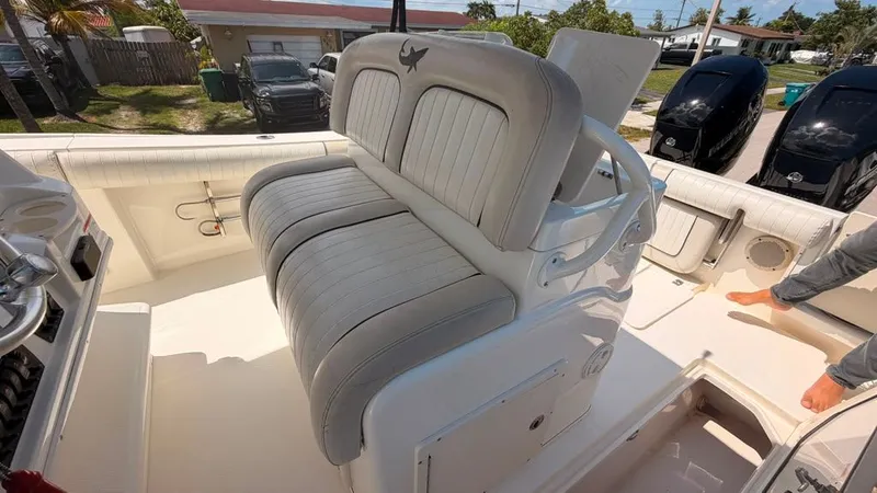 Slide: The Image of The image shows the cockpit of a 2015 Mako 284 Center Console boat with cushioned seating. - 22