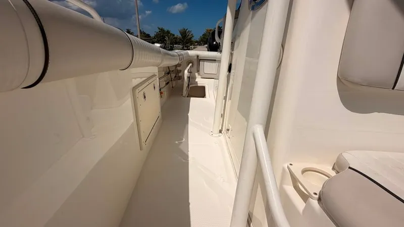 Slide: The Image of A 2015 Mako 284 Center Console with a spacious deck and white railings. - 24