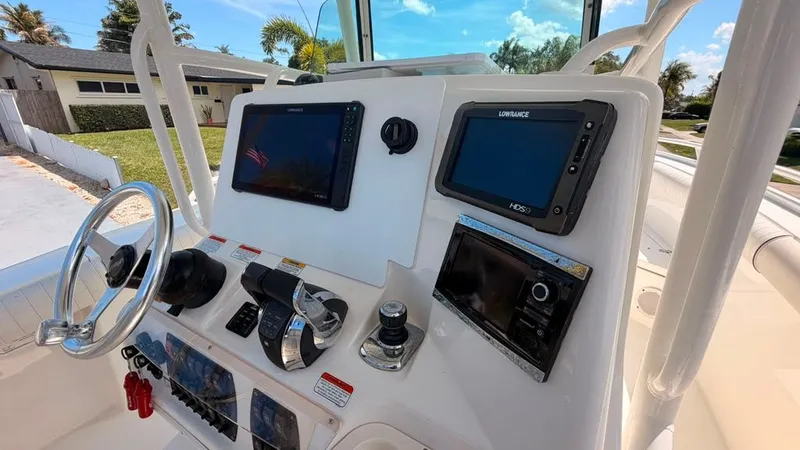 Slide: The Image of The image shows the helm of a 2015 Mako 284 Center Console boat with modern navigation equipment. - 32