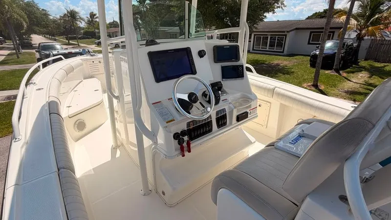 Slide: The Image of The image shows the helm of a 2015 Mako 284 Center Console boat. - 18