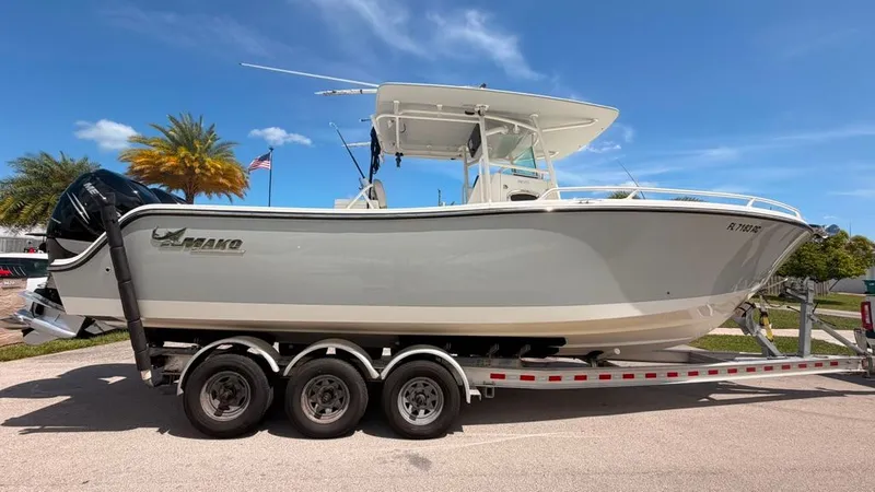 Slide: The Image of A 2015 Mako 284 Center Console boat on a trailer, with a blue sky in the background. - 8