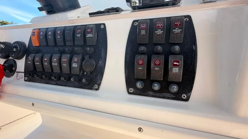 Slide: The Image of Control panel of a 2015 Mako 284 Center Console boat with various switches. - 31