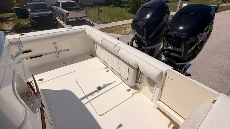 Slide: The Image of The image shows the cockpit of a 2015 Mako 284 Center Console boat with two outboard engines. - 14