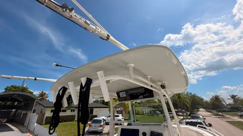 Slide: The Image of A 2015 Mako 284 Center Console boat with a T-top and fishing rod holders. - 29