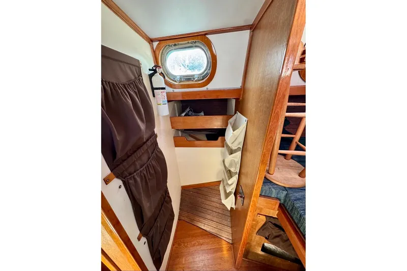 Slide: The Image of Interior of 1987 Custom Steel Cutter sailboat with wooden finishes and porthole window. - 10
