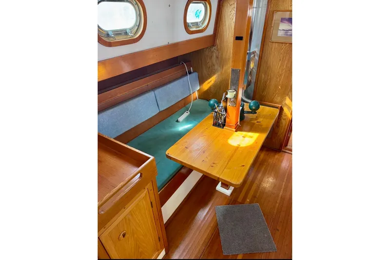 Slide: The Image of Cozy 1987 Custom Steel Cutter interior with wooden table and seating area. - 6