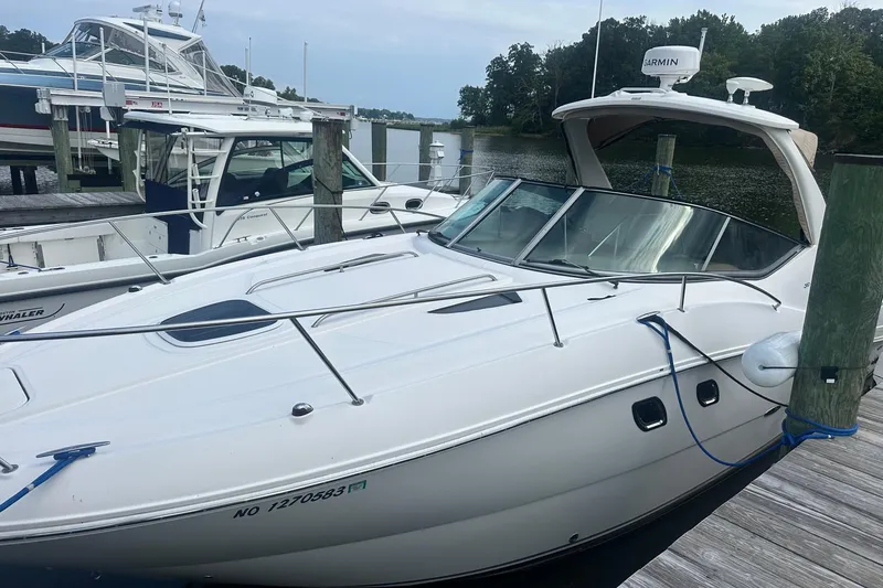 Slide: The Image of 2007 Sea Ray Sundancer 310 docked at a marina, featuring sleek white design. - 4