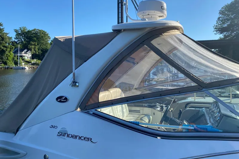 Slide: The Image of 2007 Sea Ray Sundancer 310 boat docked by a scenic riverside. - 2