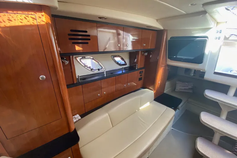 Slide: The Image of 2007 Sea Ray Sundancer 310 interior with wood cabinetry and seating area. - 29