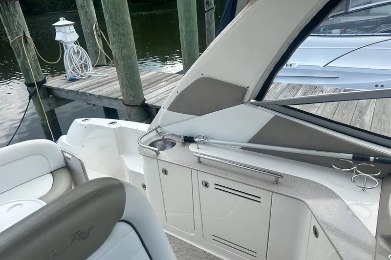 Slide: The Image of 2007 Sea Ray Sundancer 310 interior with dock view, featuring seating and storage. - 15