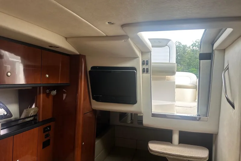 Slide: The Image of Interior of 2007 Sea Ray Sundancer 310 yacht with wood cabinetry and a mounted TV. - 27