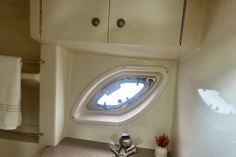 Slide: The Image of Interior of 2007 Sea Ray Sundancer 310, featuring a porthole window and sleek cabinetry. - 44
