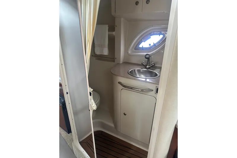 Slide: The Image of 2007 Sea Ray Sundancer 310 bathroom with sink, porthole, and wooden floor. - 42