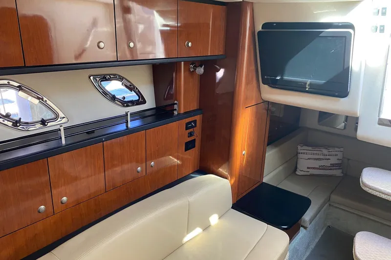 Slide: The Image of 2007 Sea Ray Sundancer 310 interior with wood cabinetry and seating area. - 28