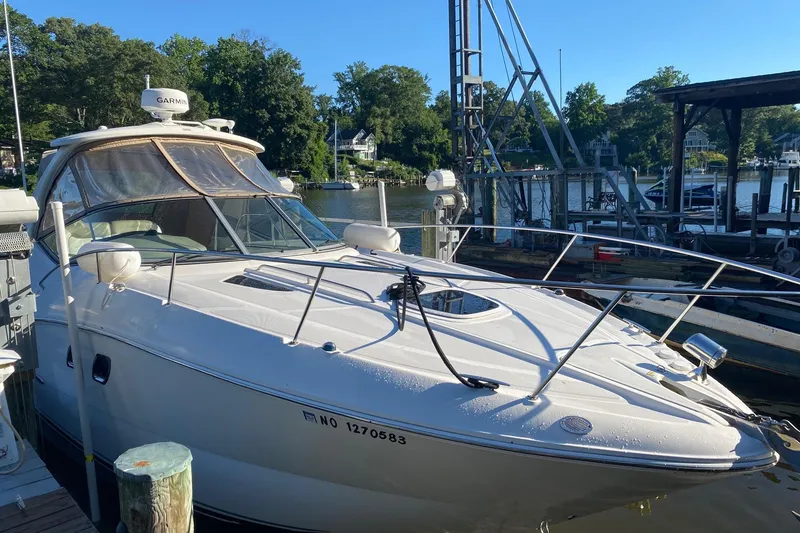 Slide: The Image of 2007 Sea Ray Sundancer 310 docked at a marina, surrounded by trees and boats. - 1