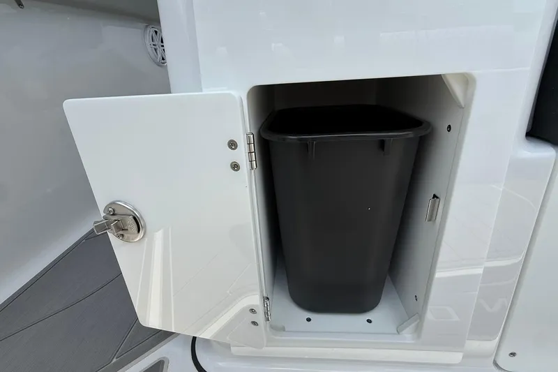 Slide: The Image of Storage compartment with trash bin on 2027 Monterey Elite 30 OB boat. - 16