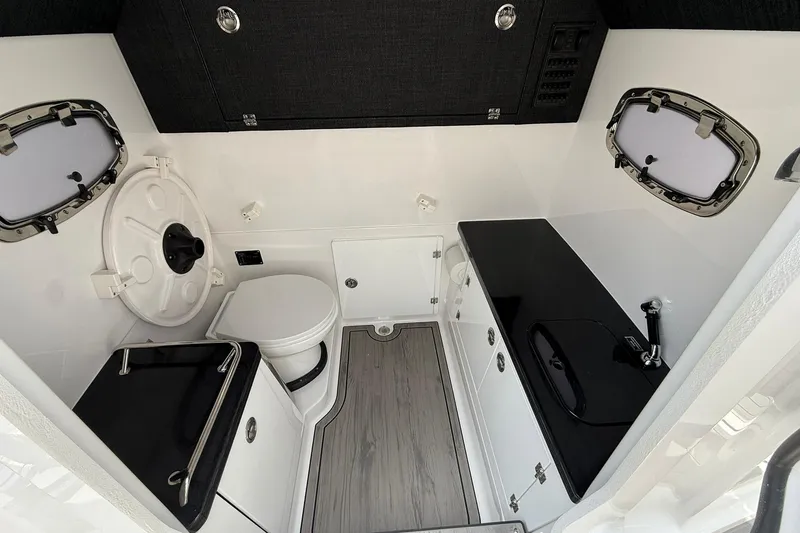 Slide: The Image of 2027 Monterey Elite 30 OB boat interior with modern bathroom and sleek black countertops. - 7