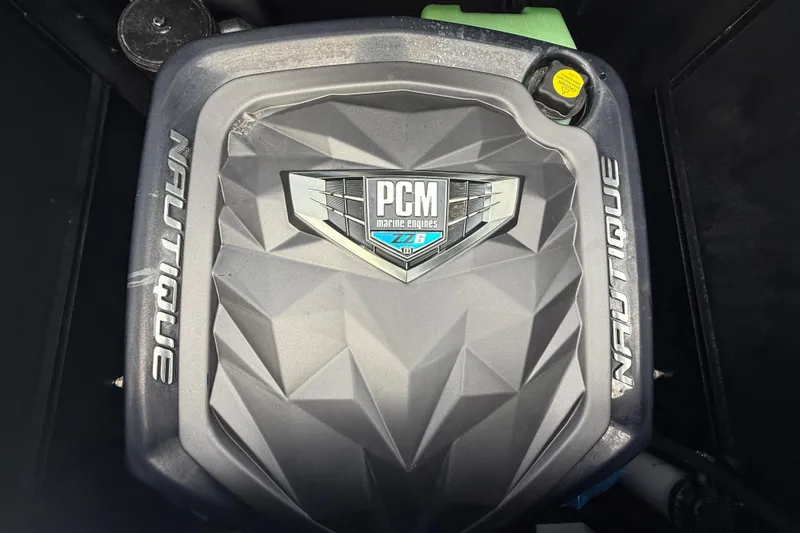Slide: The Image of 2021 Nautique Super Air Nautique G25 Coastal Edition engine cover with PCM branding. - 10