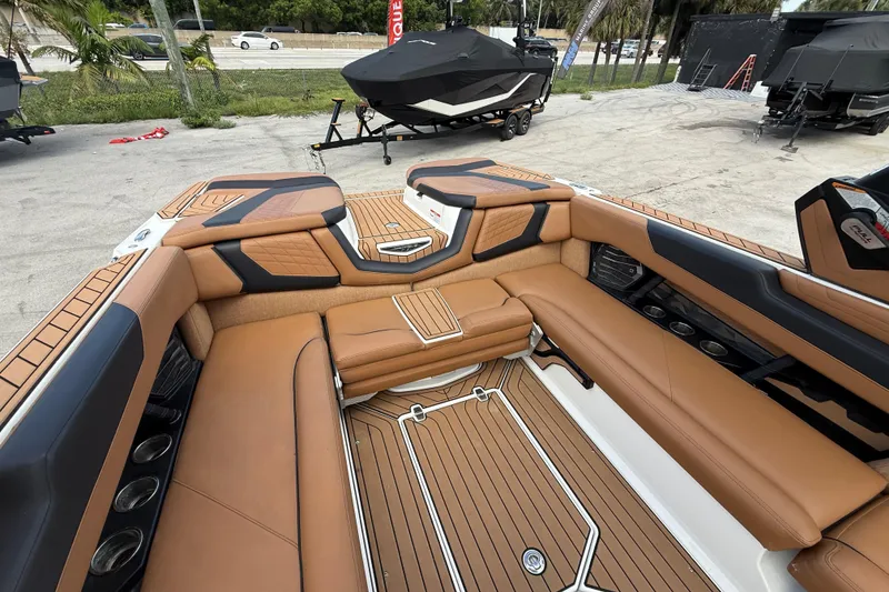 Slide: The Image of 2021 Nautique Super Air Nautique G25 Coastal Edition interior with tan seating and teak flooring. - 5