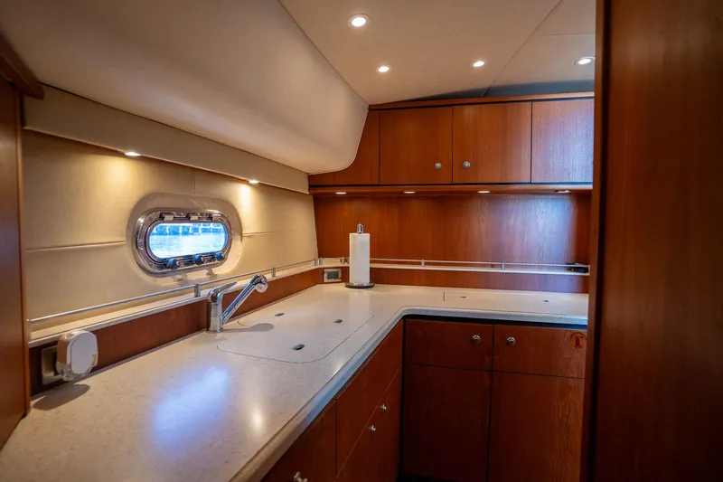 Slide: The Image of Interior view of a 2008 Tiara Yachts 4300 Sovran galley with wood cabinets and countertop. - 32
