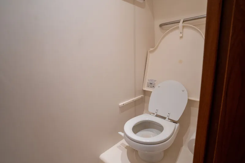 Slide: The Image of Interior view of a boat toilet with white seat and walls. - 29