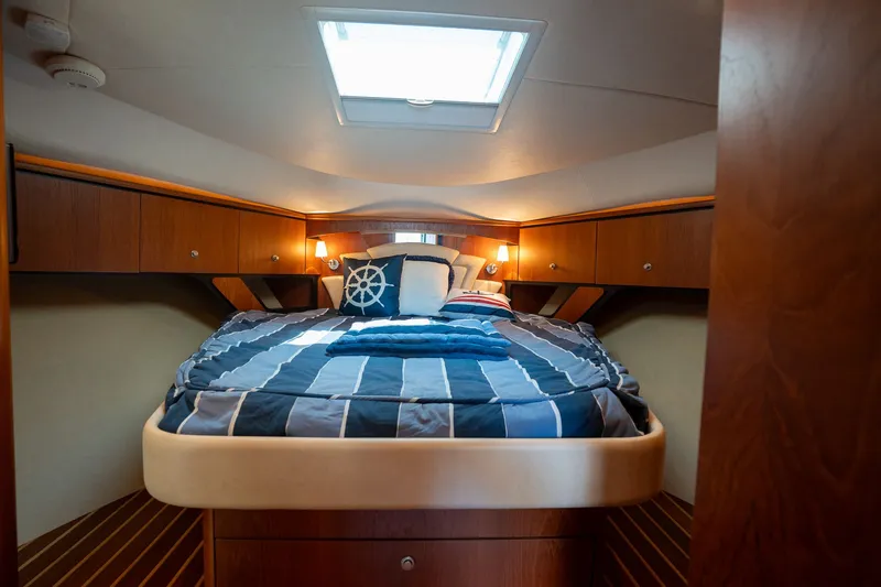 Slide: The Image of The cabin of the 2008 Tiara Yachts 4300 Sovran features a cozy bed with striped bedding. - 20