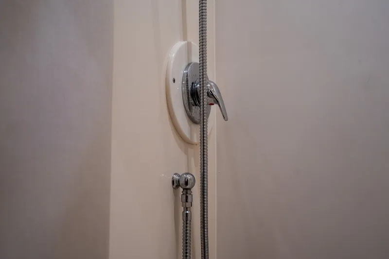 Slide: The Image of Close-up of a shower handle and showerhead in a boat bathroom. - 30