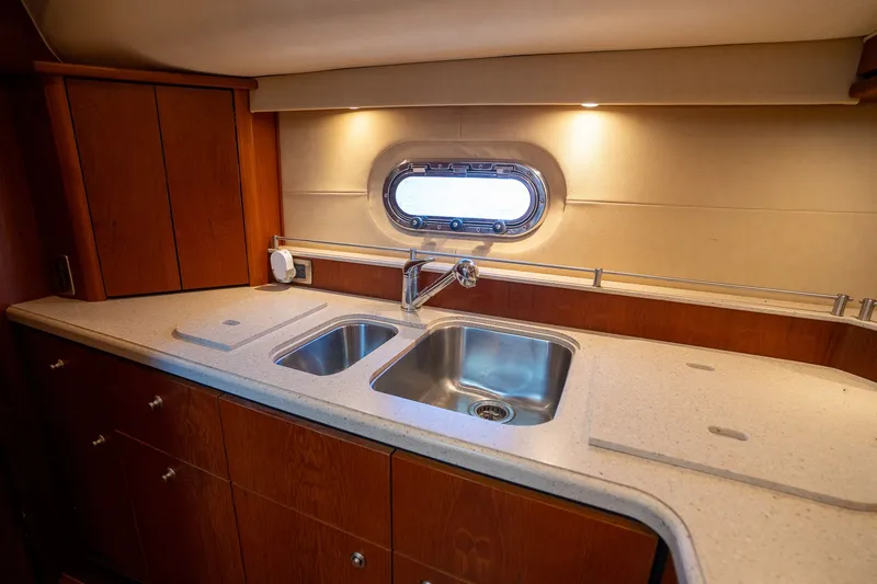 Slide: The Image of Interior view of the 2008 Tiara Yachts 4300 Sovran featuring a sleek kitchen and porthole. - 24