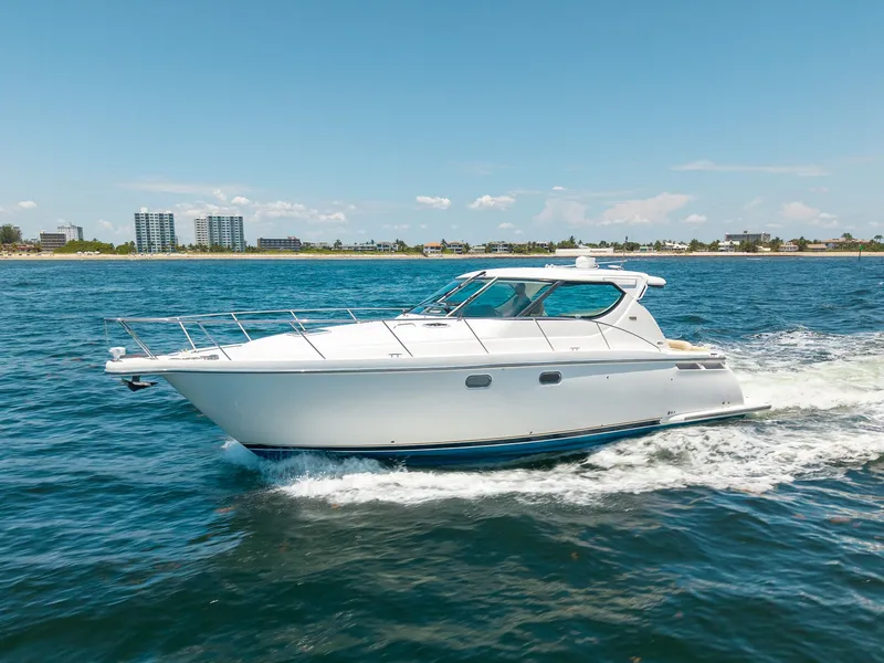 Slide: The Image of A 2008 Tiara Yachts 4300 Sovran cruising on the water near the coastline. - 3