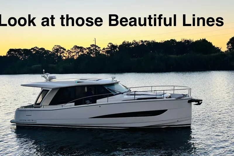 Slide: The Image of 2021 Greenline 39 Hybrid yacht on serene water at sunset, showcasing sleek design. - 31