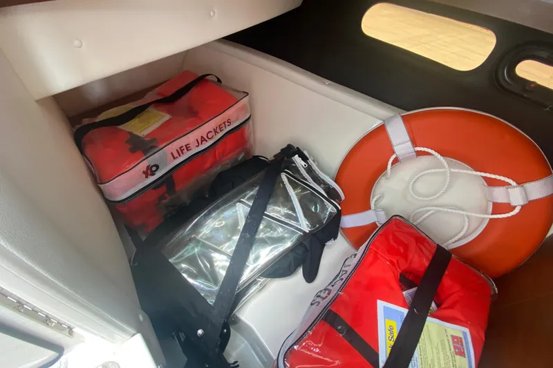 Slide: The Image of Safety equipment storage on 2018 Sea Ray SLX 350, featuring life jackets and a lifebuoy. - 34