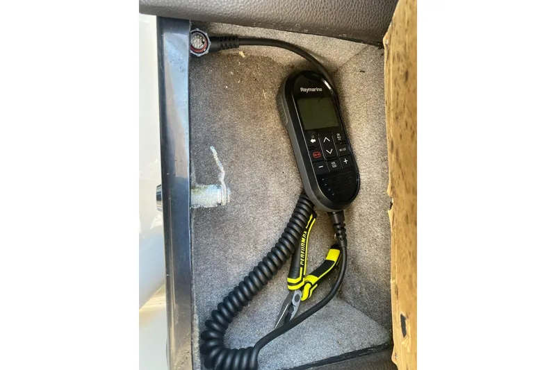 Slide: The Image of Raymarine remote control and pliers in a 2018 Sea Ray SLX 350 compartment. - 51