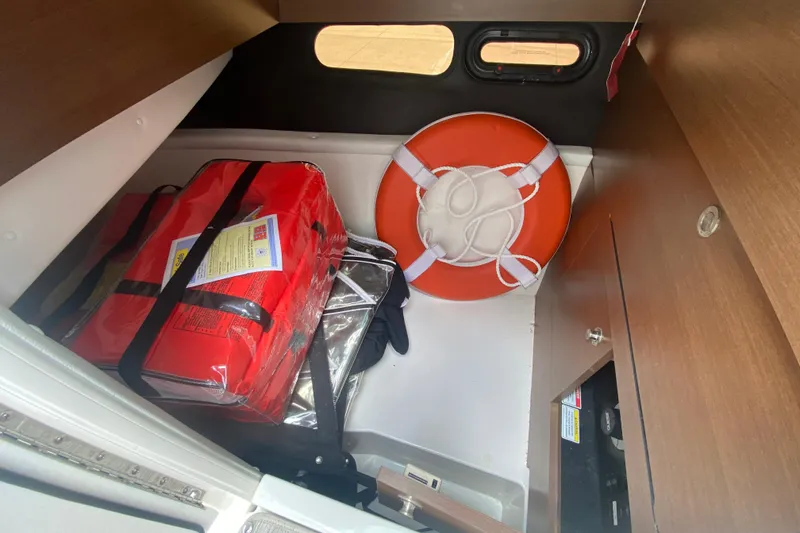Slide: The Image of Storage compartment in a 2018 Sea Ray SLX 350 with life preserver and safety gear. - 31